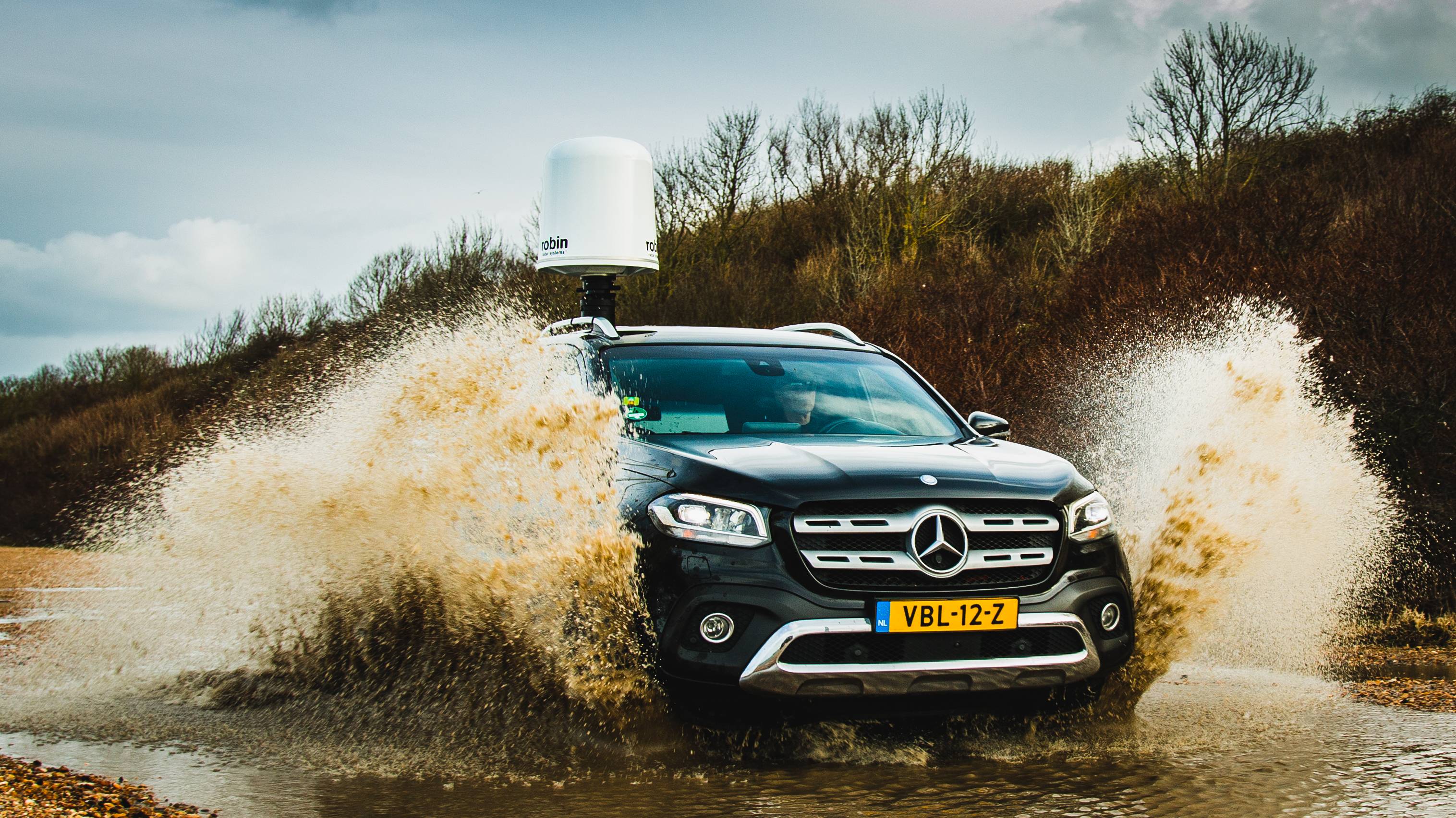 Iris product on top of car driving through mud