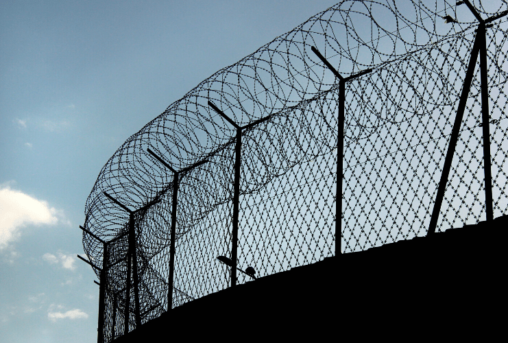 Chain link prison security fence at twilight