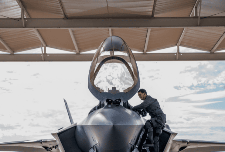 Pilot entering the cockpit of a military fighter plane that's protected by bird and counter UAS radar